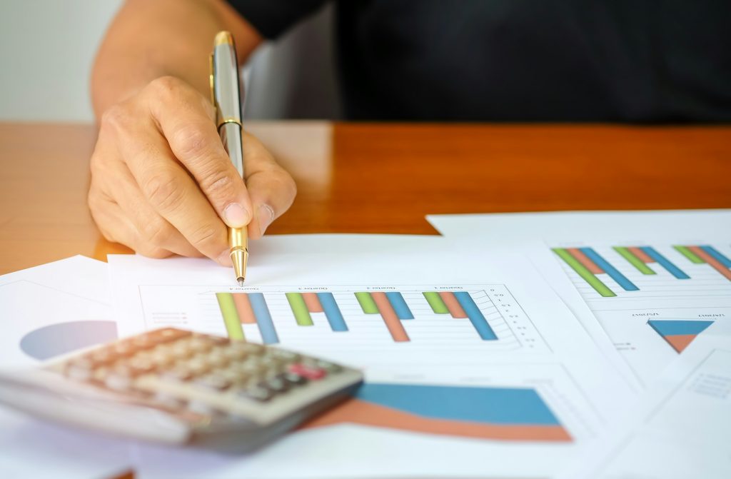 Men are using a calculator to analyze income data.